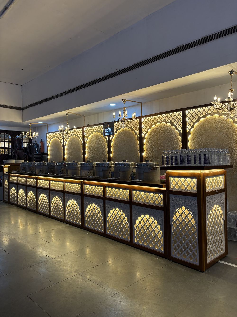 A buffet counter lit from within with carved arch panels