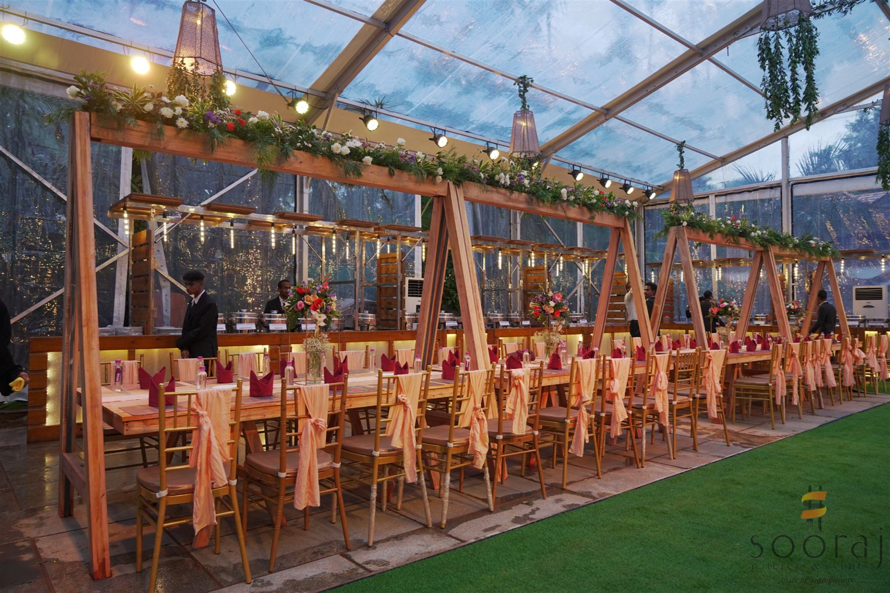 Long banquet tables under a teak-framed canopy